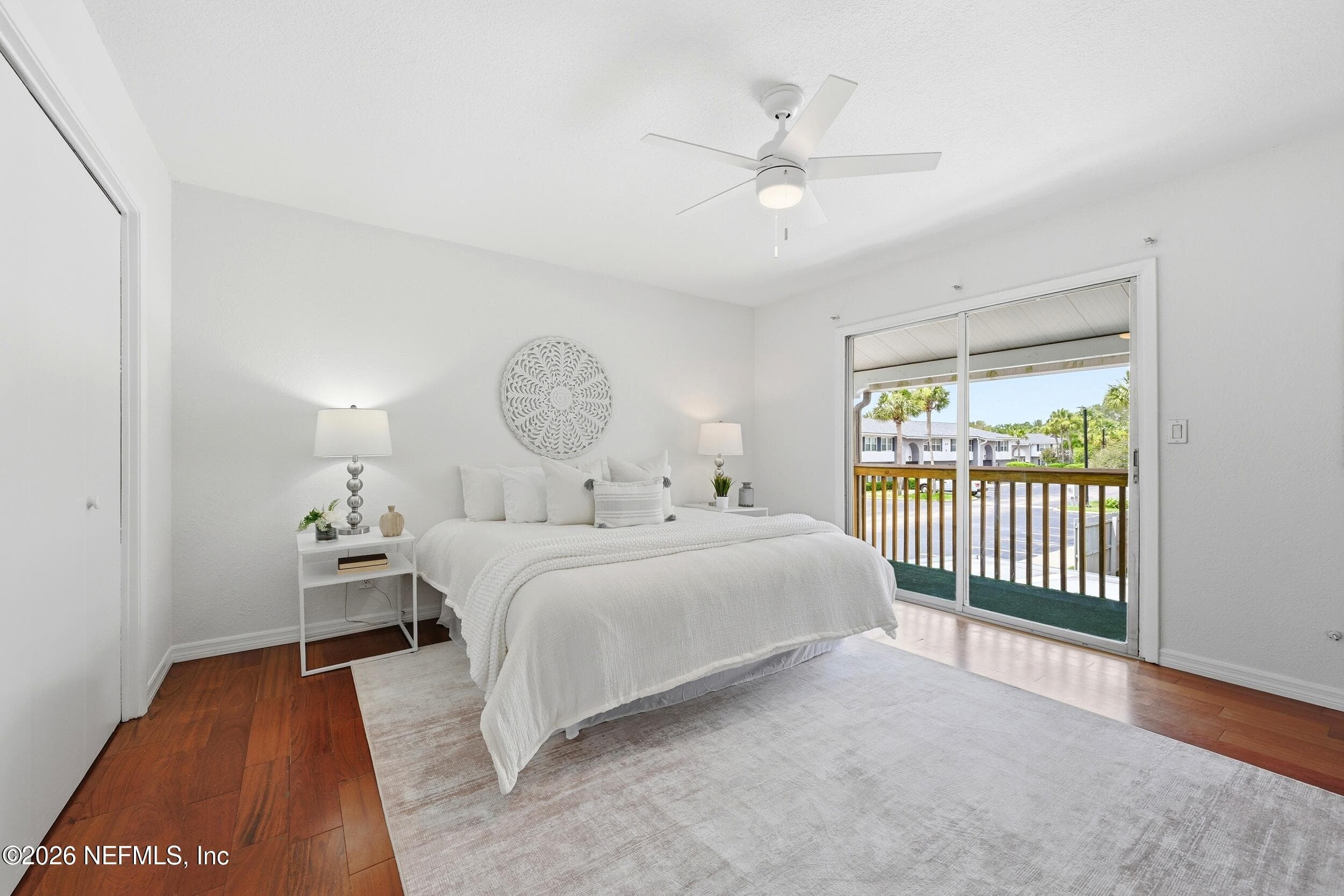 Spacious primary suite with wood flooring, private balcony, custom closet shelving, and en-suite bath — 695 N A1A 25, Ponte Vedra Beach, FL 32082